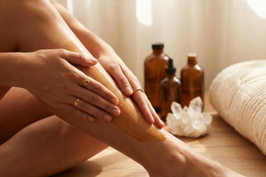 Woman applying oils and lotion to her legs