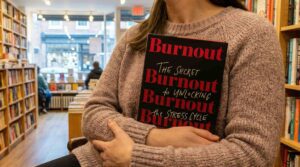 Woman holding the book Burnout in her arms at a book store